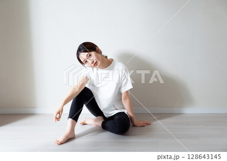 床に座る若い女性のポートレート 128643145