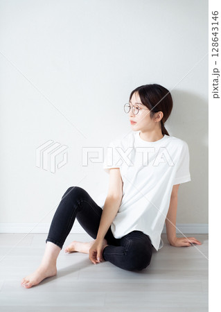 床に座る若い女性のポートレート 128643146