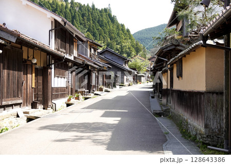 石見銀山 町並み地区のノスタルジックな古民家と緑豊かな山並み 128643386