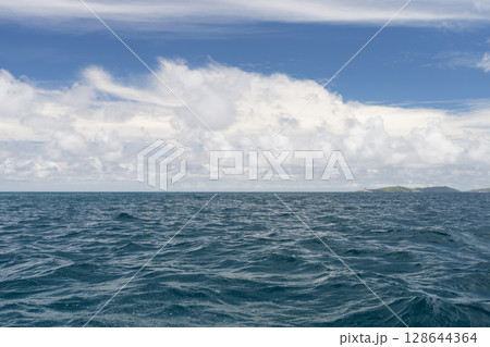 Ocean waves with turquoise water and white clouds 128644364