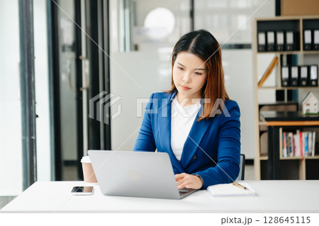 Confident business expert attractive smiling young woman holding digital tablet on desk in creative office. Confident business expert attractive smiling young woman holding digital tablet on desk in creative office. 128645115