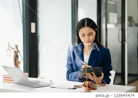 justice and law concept. asian woman lawyer working and judge in a courtroom the gavel, working with tablet and laptop 128645474