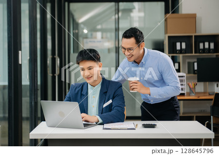 Male discussing new project with business colleague. Young man talking with young man in office. Male discussing new project with business colleague. Young man talking with young man in office. 128645796