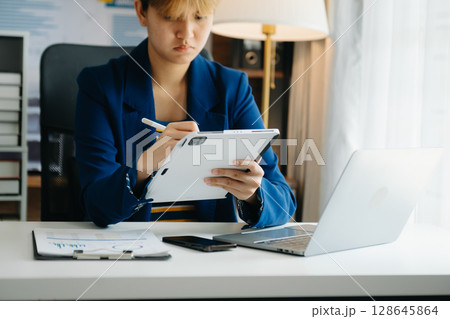 Woman freelancer is working her job on computer tablet and laptop Doing accounting analysis report real estate investment data, Financial at office 128645864
