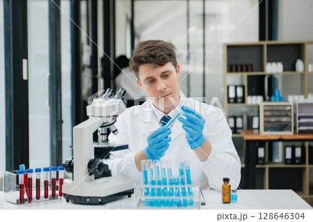 Male biotechnologist testing new chemical substances in a laboratory. Male biotechnologist testing new chemical substances in a laboratory. 128646304
