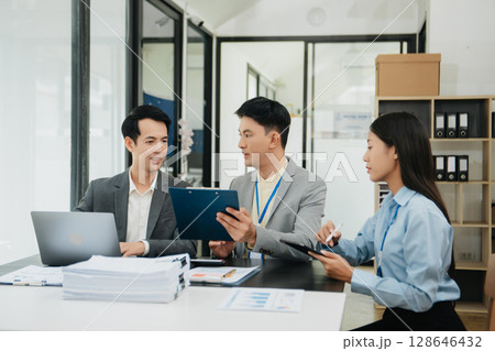 Office colleagues have a casual discussion. During a meeting in a conference room, a group of business teem sit in office room new startup project 128646432