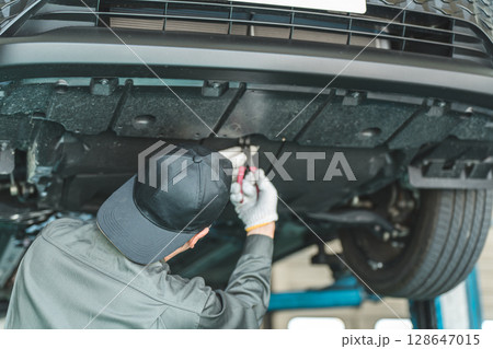 リフトに上がる車両の下で整備・点検・作業をする自動車整備士の男性 128647015