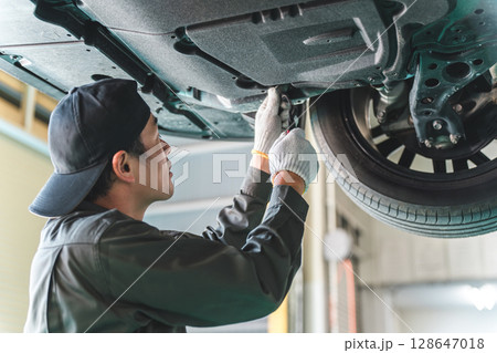 リフトに上がる車両の下で整備・点検・作業をする自動車整備士の男性 128647018