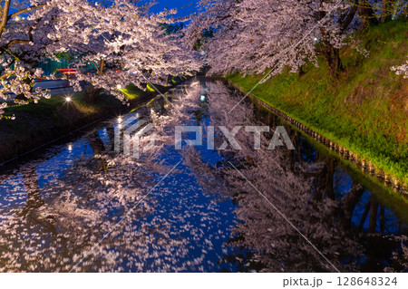 青森県弘前市下白銀町弘前公園　弘前城外堀を囲むソメイヨシノの桜並木ライトアップと水面の水鏡 128648324