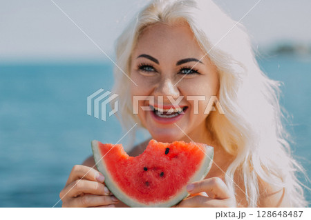 Woman Watermelon Beach Summer: Happy woman enjoys watermelon slice at sunny beach during summer vacation. Woman Watermelon Beach Summer: Happy woman enjoys watermelon slice at sunny beach during summer vacation. 128648487