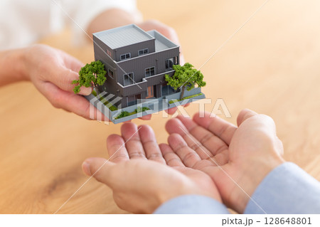 住宅を手渡すミドル夫婦の手元 住宅を手渡すミドル夫婦の手元 128648801