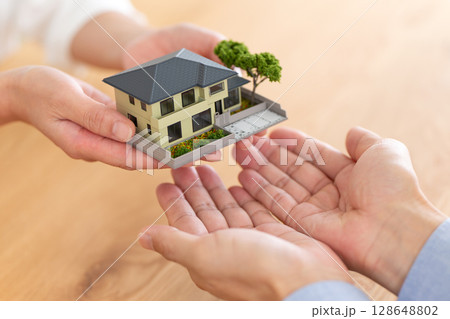 住宅を手渡すミドル夫婦の手元 128648802