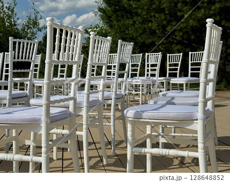 White chairs for the guests of the wedding ceremony are on the site. High quality photo 128648852