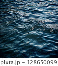 Calm water surface with gentle ripples reflecting light, creating a serene atmosphere, ideal for backgrounds or nature-themed projects showcasing tranquility and beauty 128650099