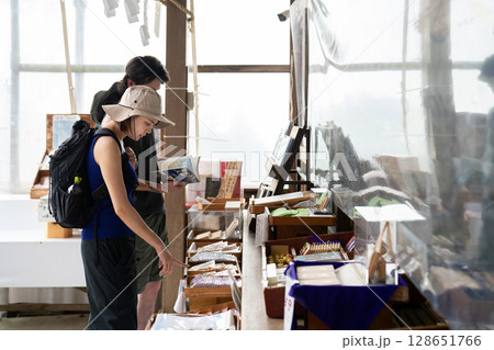 神社の売店でお土産を選ぶインバウンドの二人 128651766