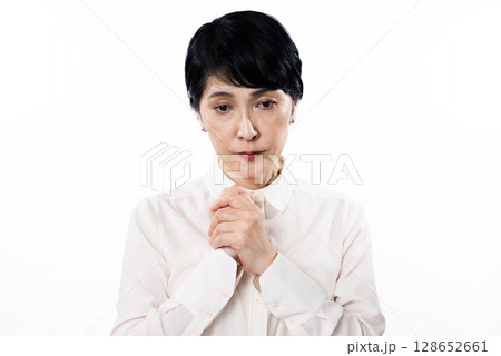寂しそうな表情の白いシャツを着た中年女性 寂しそうな表情の白いシャツを着た中年女性 128652661