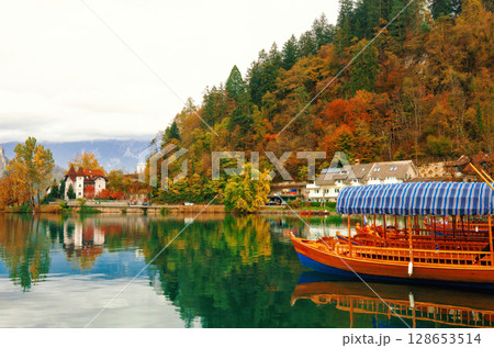 Autumn landscape with lake Bled, tradition wooden Pletna boats and old villa in Slovenia Autumn landscape with lake Bled, tradition wooden Pletna boats and old villa in Slovenia 128653514