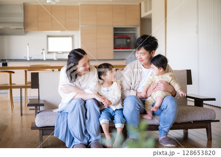 木のぬくもりのある新築のような家の自宅のソファーでくつろぐ4人の日本人家族 木のぬくもりのある新築のような家の自宅のソファーでくつろぐ4人の日本人家族 128653820