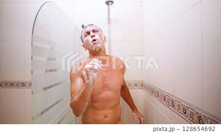 Man singing enthusiastically in the shower 128654692