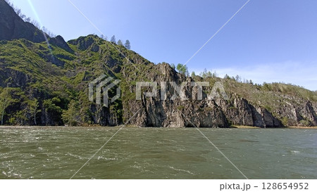 Majestic Mountain River Landscape A Scenic View of Lush Greenery Under a Clear Blue Sky 128654952