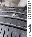 screw puncturing car tire. macro closeup. 128655257