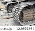 Metal excavator track background. Construction site ground. Heavy machinery equipment. 128655264