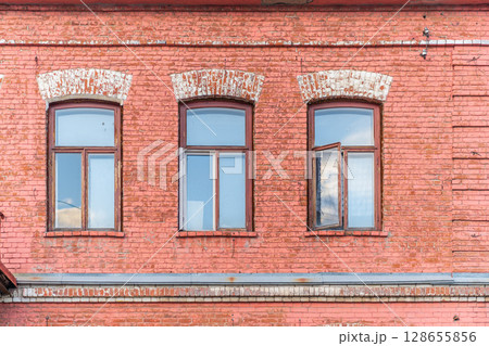 Three windows of the old mansion 19 century with brown bricks wall Three windows of the old mansion 19 century with brown bricks wall 128655856