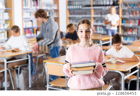 Portrait of a ten-year-old schoolgirl with textbooks Portrait of a ten-year-old schoolgirl with textbooks 128656453