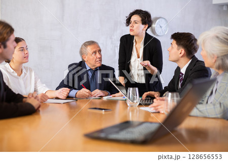 Female director gives instructions to managers in deliberation room Female director gives instructions to managers in deliberation room 128656553