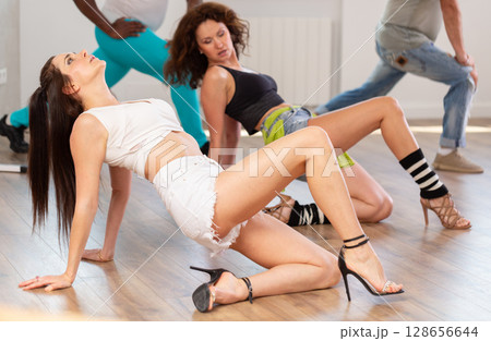 Women in heels dancing on floor in studio Women in heels dancing on floor in studio 128656644