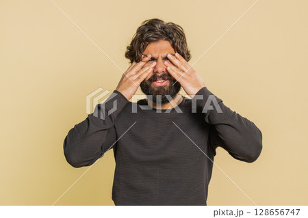 Indian shocked bearded man guy closing eyes with hands showing stop gesture over beige background Indian shocked bearded man guy closing eyes with hands showing stop gesture over beige background 128656747