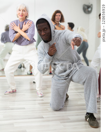 African American man practicing hip-hop movements during group class 128656919