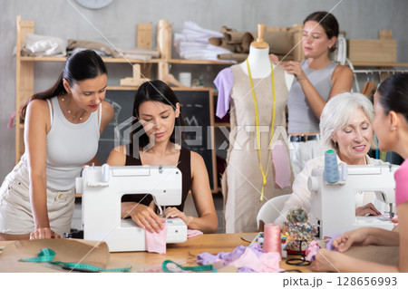 Group of women sew and work with mannequin at master class Group of women sew and work with mannequin at master class 128656993