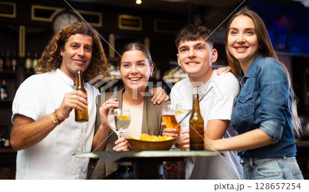 Portrait of happy friends in beer bar chatting and drinking beer 128657254