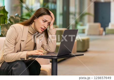 Caucasian businesswoman girl using laptop surprised by bad news, fortune loss, fail, lottery results 128657649