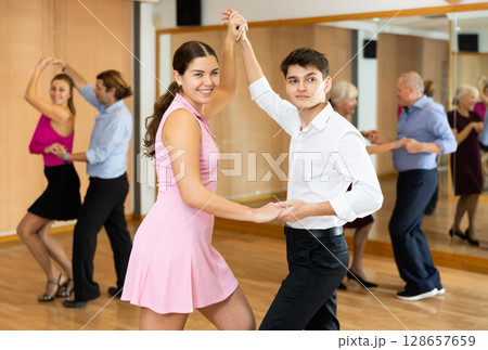 Young couple enjoying impassioned merengue in latin dance class Young couple enjoying impassioned merengue in latin dance class 128657659