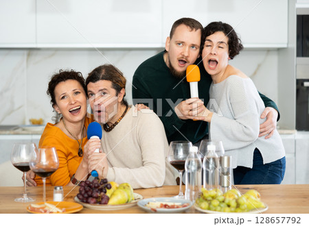 Group of friends are having fun singing karaoke during feast and gatherings. 128657792