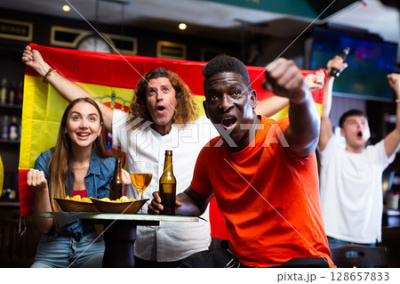 Happy fans celebrating the victory of Spanish team in bar 128657833