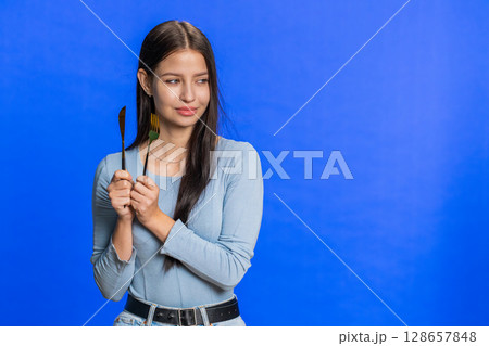 Hungry woman waiting for serving dinner meal dishes with restlessness holding cutlery fork knife Hungry woman waiting for serving dinner meal dishes with restlessness holding cutlery fork knife 128657848