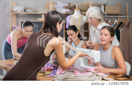 Two women discussing pattern at sewing master class 128657976