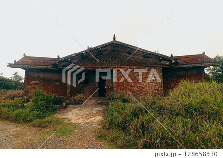 An old weathered brick abandoned villa called Damnak Sla Khmao or Black Palace in Bokor Hill Kampot Cambodia, a popular tourist attraction 128658310
