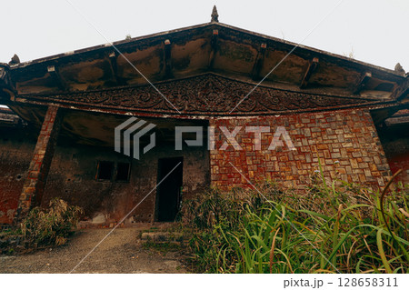An old abandoned weathered building with ornate details and overgrown plants called Damnak Sla Khmao or Black Palace in Bokor Hill Kampot Cambodia, a popular tourist attraction An old abandoned weathered building with ornate details and overgrown plants called Damnak Sla Khmao or Black Palace in Bokor Hill Kampot Cambodia, a popular tourist attraction 128658311