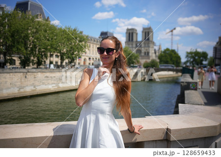 Woman posing near Notre Dame Paris summer 2025 128659433