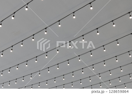 Soft glowing string lights hang across the ceiling creating a warm atmosphere 128659864