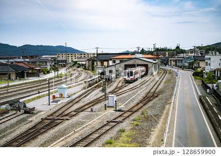 地方の鉄道と車庫のある町並み風景(夏の青空) 地方の鉄道と車庫のある町並み風景(夏の青空) 128659900