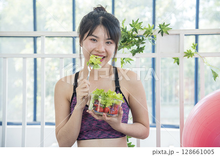 Wellness Asian women dressing organic green salad tomato vegetable dish. Beautiful girl healthcare vegan wellness lifestyle concept. Healthy woman workout holding organic salad bowl healthy lifestyle Wellness Asian women dressing organic green salad tomato vegetable dish. Beautiful girl healthcare vegan wellness lifestyle concept. Healthy woman workout holding organic salad bowl healthy lifestyle 128661005