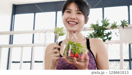Healthy woman workout holding organic salad bowl healthy lifestyle. Wellness Asian women dressing organic green salad tomato vegetable dish. Beautiful girl healthcare vegan wellness lifestyle concept 128661013