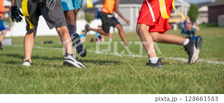 Youth athletes participate in flag football practice on a sunny day in a community park, showcasing teamwork and skill development Youth athletes participate in flag football practice on a sunny day in a community park, showcasing teamwork and skill development 128661583
