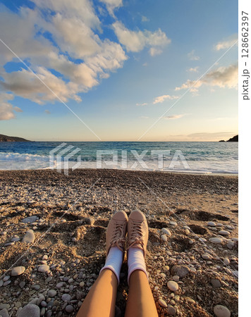 close up of feet in shoes on the beach 128662397