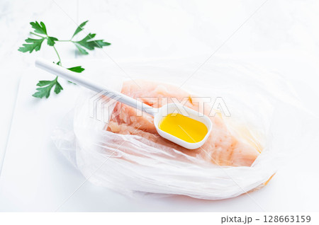 鶏むね肉にオリーブオイルを加える 128663159